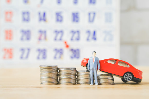 微型商人和硬币堆在浅棕色的木头上模糊微型汽车和日历，商业，金融，新车，目标概念图片下载