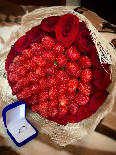 订婚戒指和一束新鲜草莓图片下载