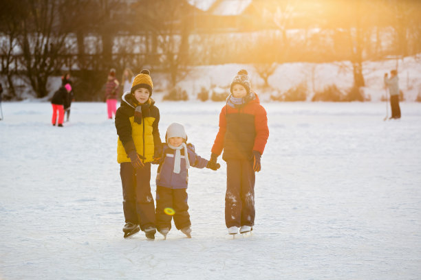 快乐的孩子们，在公园结冰的湖面上滑冰图片下载
