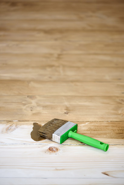 木地板上的方剪刷子。用污渍调色地板，增强纹理。装修过程。在涂漆前阶段图片下载