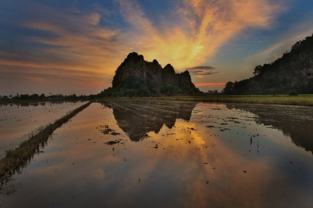 日落时的稻田、山脉和壮观的天空和云彩景观。图片下载