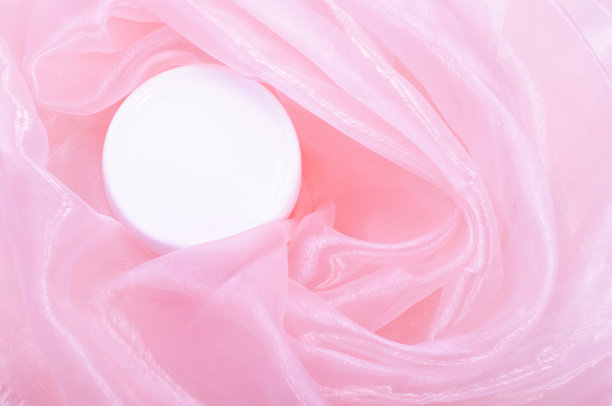 白色奶油色的罐子，背景是粉红色的丝绸。平躺，俯视图，拷贝空间。天然有机产品，美容和水疗概念。玫瑰化妆品图片下载