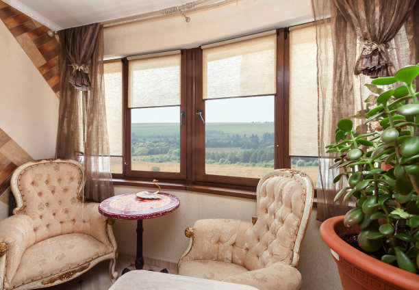 现代复古设计阁楼。小的老式桌子和扶手椅在窗户下放松。图片下载