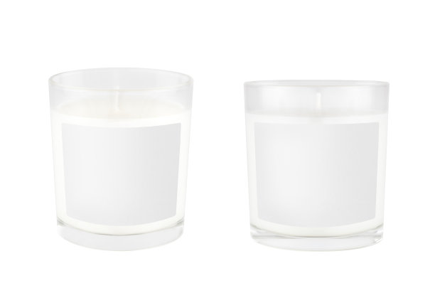 两个白色蜡烛在透明玻璃与白色空白标签隔离，模拟的品牌身份，广告，展示，设计包装。图片下载