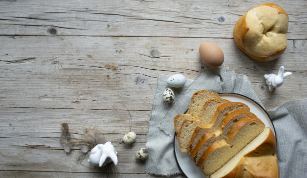 美味新鲜的复活节条纹被切在盘子上，装饰兔子和鸡蛋在木制的背景图片下载