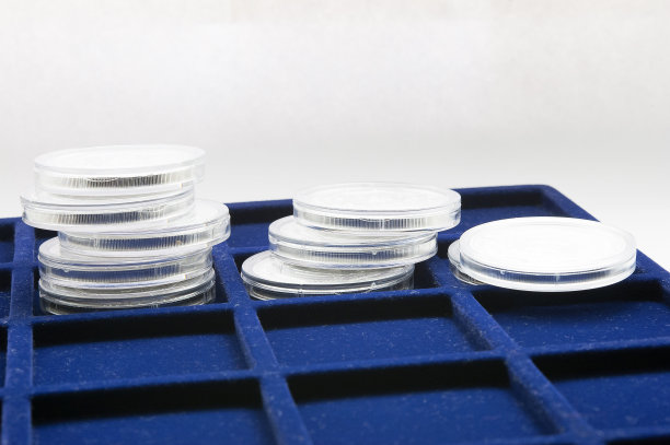 蓝色托盘上放着一堆堆硬币图片下载