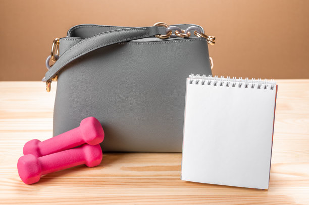 女士皮革灰色手提包，记事本和粉色小哑铃。做清单的模型，概念计划训练，运动计划，健身，普拉提图片下载