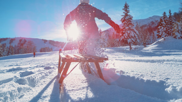 近距离观察:一个面目全的女人驾着雪橇跑进了厚厚的粉雪中。图片下载