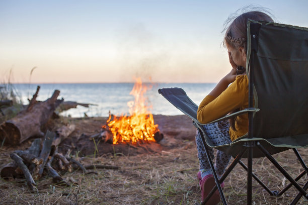家庭的地方度假。孩子们晚上在营地看火，积极的生活方式图片下载