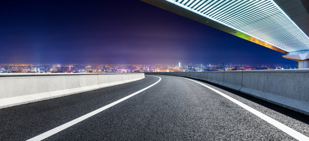 在上海，柏油路和桥与城市天际线在晚上。图片下载