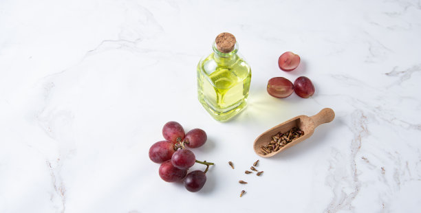天然膳食和素食葡萄籽油在玻璃瓶上白色大理石背景。健康的饮食和生活方式图片下载