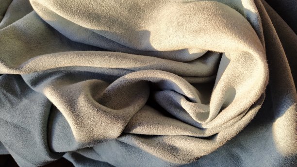 客厅里挂着灰蓝色的天鹅绒窗帘。织物被折叠成波浪状。短桩。光在衣服的褶皱中嬉戏。美观，手感好，材质昂贵图片下载