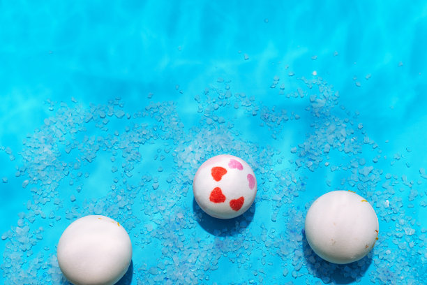 炸弹和浴盐在蓝色背景与水反射，淋浴化妆品概念，俯视图，复制空间图片下载