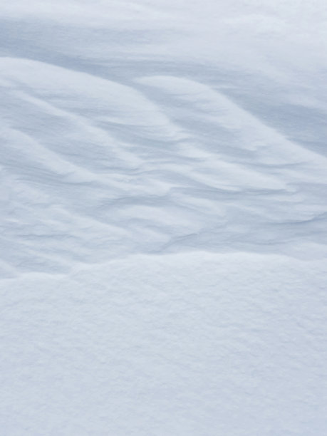 纯白的雪背景纹理。冬季背景与雪堤岸。一场暴风雪过后会有积雪。季节景观的细节。寒冷的天气。图片下载