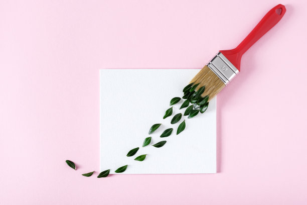 一笔绿色的树叶和画笔在粉背景图片下载