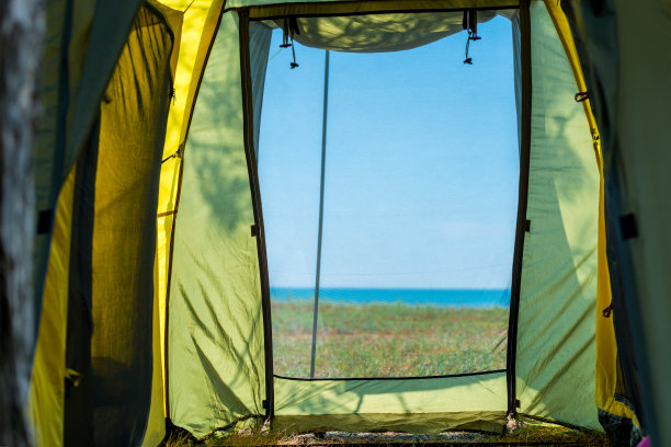 在一个阳光明媚的夏日俯瞰大海的露营帐篷里图片下载