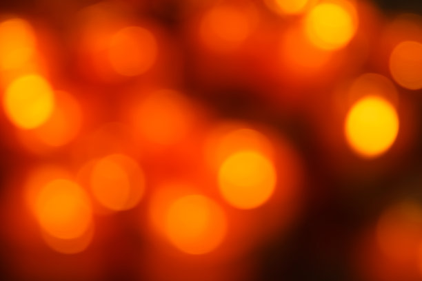 圣诞背景红色假日抽象灯散焦和闪烁抽象红橙色散焦，金色和黑色闪烁灯与黑色背景。图片下载