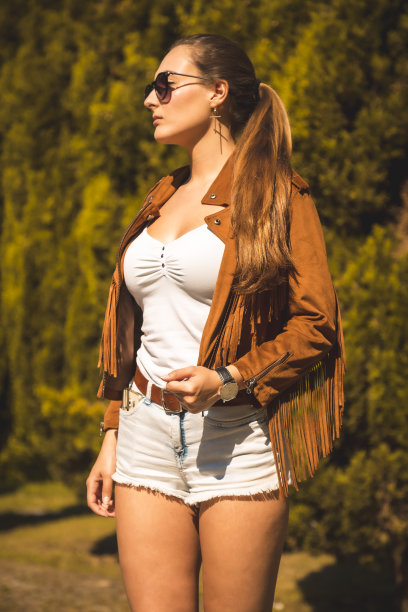 街头风格，一个漂亮的金发女郎穿着白色t恤在夏天拿着她的马尾辫图片下载