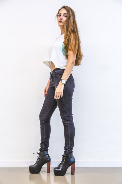 街头风格，一个美丽苗条的深色头发与胶水裤子和高跟鞋图片下载