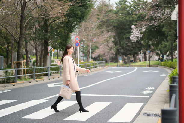 一个女人走在春天的城市里图片下载