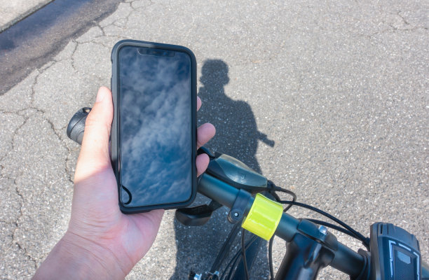 一个人一边骑自行车一边看智能手机的图片。危险驾驶。图片下载
