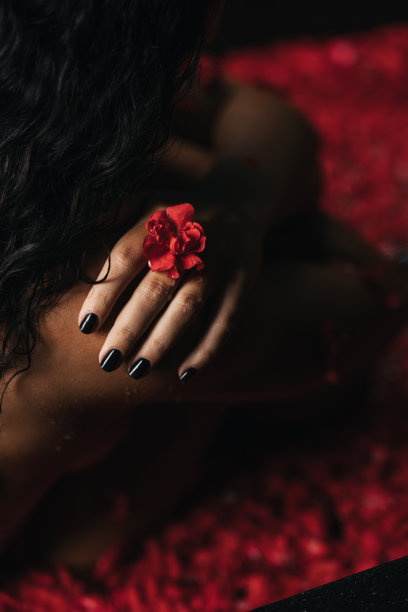 美丽的女性在沐浴与玫瑰花瓣。身体保健。图片下载