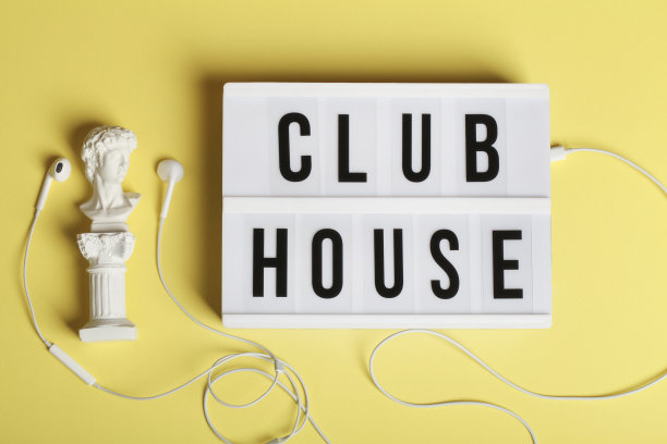 白色耳机与小雕像和灯箱与文本会所黄色背景。俯视图平铺图片下载