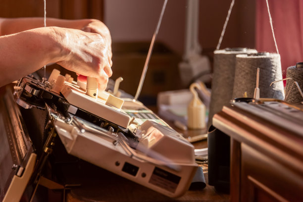 妇女的手在编织机上工作图片下载