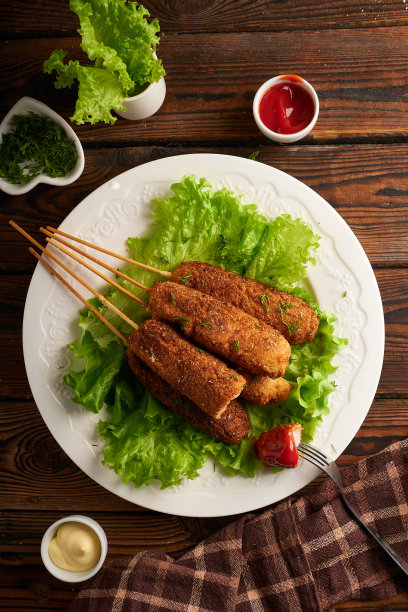 美味的玉米热狗配酱汁和沙拉，盛在白色的盘子里图片下载