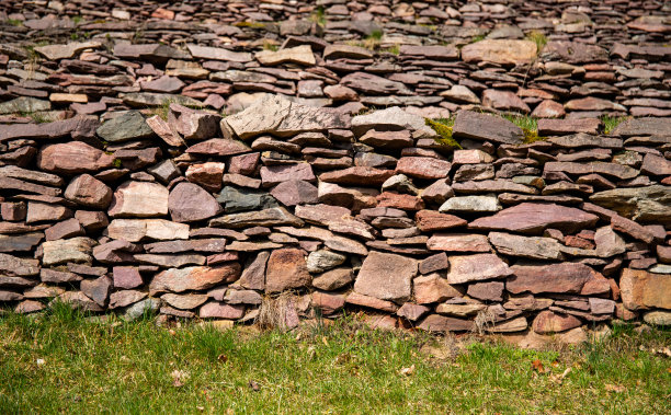 一堵由红褐色天然石头砌成的墙，砖石结构图片下载