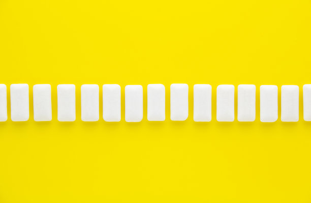 黄色背景上的白色口香糖线。新鲜薄荷泡泡糖。图片下载