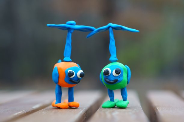 两架橡皮泥做的玩具直升机在公园的长椅上。图片下载