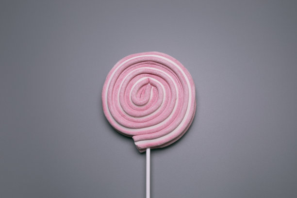 灰色背景上的粉色棒棒糖。图片下载