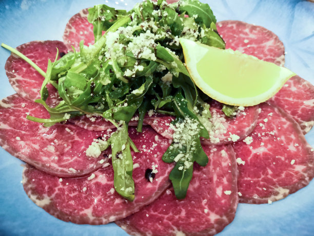 餐厅的餐桌上，有大理石花纹的生牛肉片，选择性聚焦，智能手机上的照片，噪音图片下载