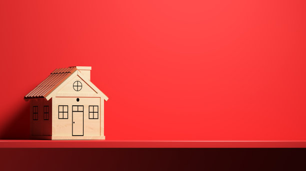 木制的玩具房子站在红色的木头前面的红色背景图片下载