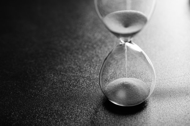 沙子通过一个沙漏测量旅行时间倒计时到最后期限，黑白照片图片下载