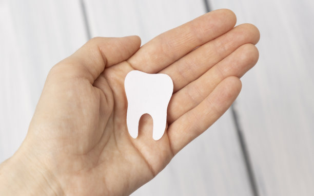 牙齿雕像手在木制背景。意思是照顾口腔。图片下载