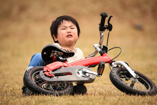 一个在练习骑自行车时摔倒的男孩图片下载