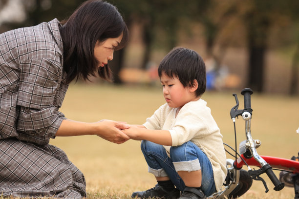 一个在练习骑自行车时摔倒的男孩图片下载