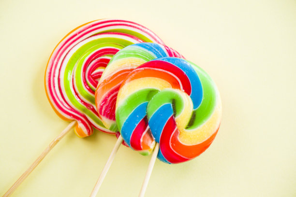 五颜六色的糖果，棒棒糖在五颜六色的背景上，五彩缤纷图片下载