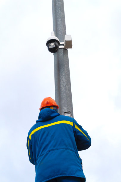 一个正在工作的安装人员安装和连接街道监控摄像头图片下载