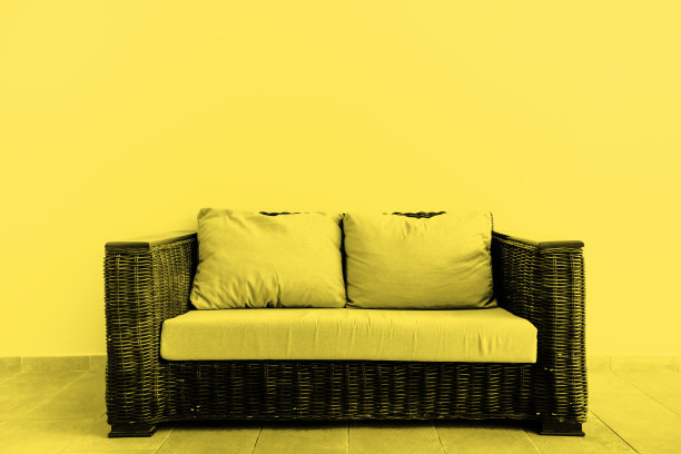 室外米色墙壁上的藤条沙发。2021年的流行色-终极灰色和照明图片下载