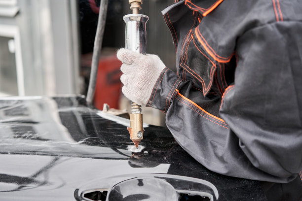 焊机，用于矫正车身凹痕的焊机。金属点焊。维修工修理损坏的汽车。图片下载