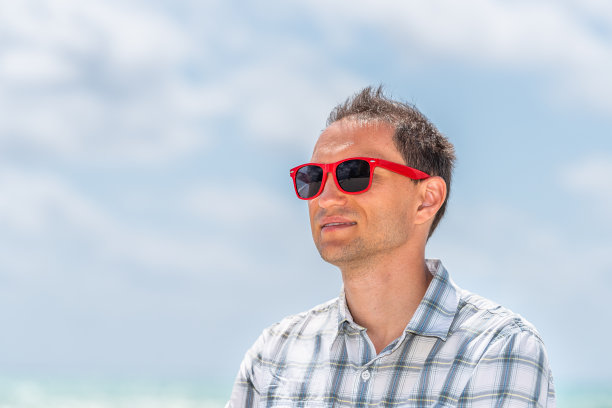 年轻英俊有吸引力的男人潮人千禧快乐的脸特写在阳光明媚的一天与红色太阳镜在迈阿密，佛罗里达图片下载