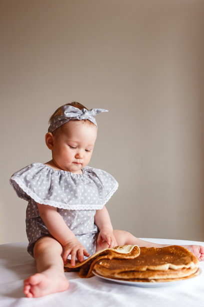 婴儿坐在桌子上的垂直照片。俄罗斯的狂欢节图片下载