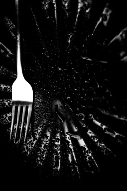 一个黑色的空盘子和叉子，湿盘子，咖啡馆阳台上美丽的雨滴图片下载