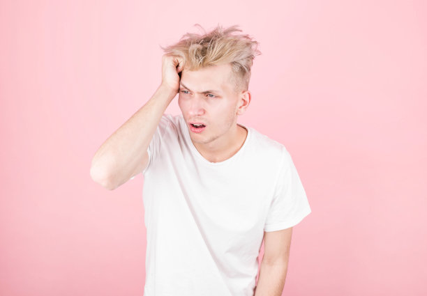 这张横放的照片上是一位英俊的白人男子，在右侧粉色背景的孤立映衬下，显示出他的头有多疼，他很痛苦，看起来很痛苦，疲惫不堪。图片下载