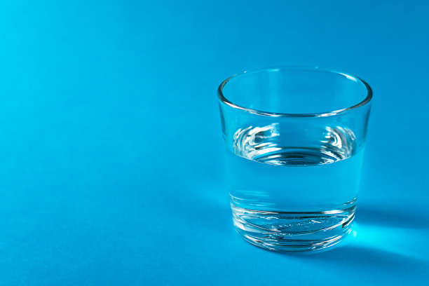 一个有蓝色背景的水的杯子。图片下载