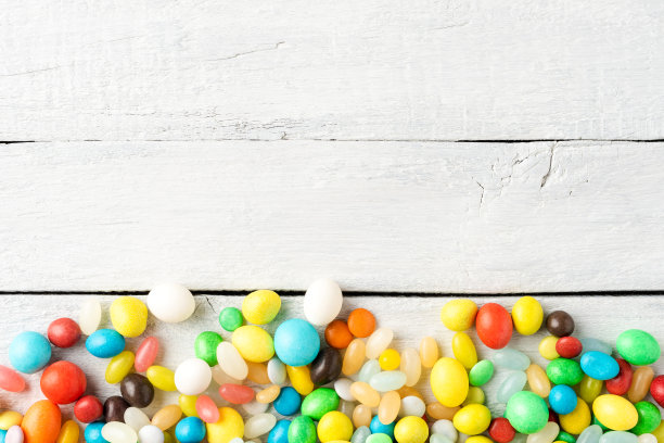混合彩色糖果在白色木制背景与copyspace图片下载