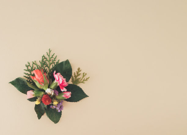 色彩柔和的背景上点缀着春天的花朵。浪漫色彩斑斓的花朵，玫瑰，绿叶。最小的平面布局概念与复制空间。图片下载